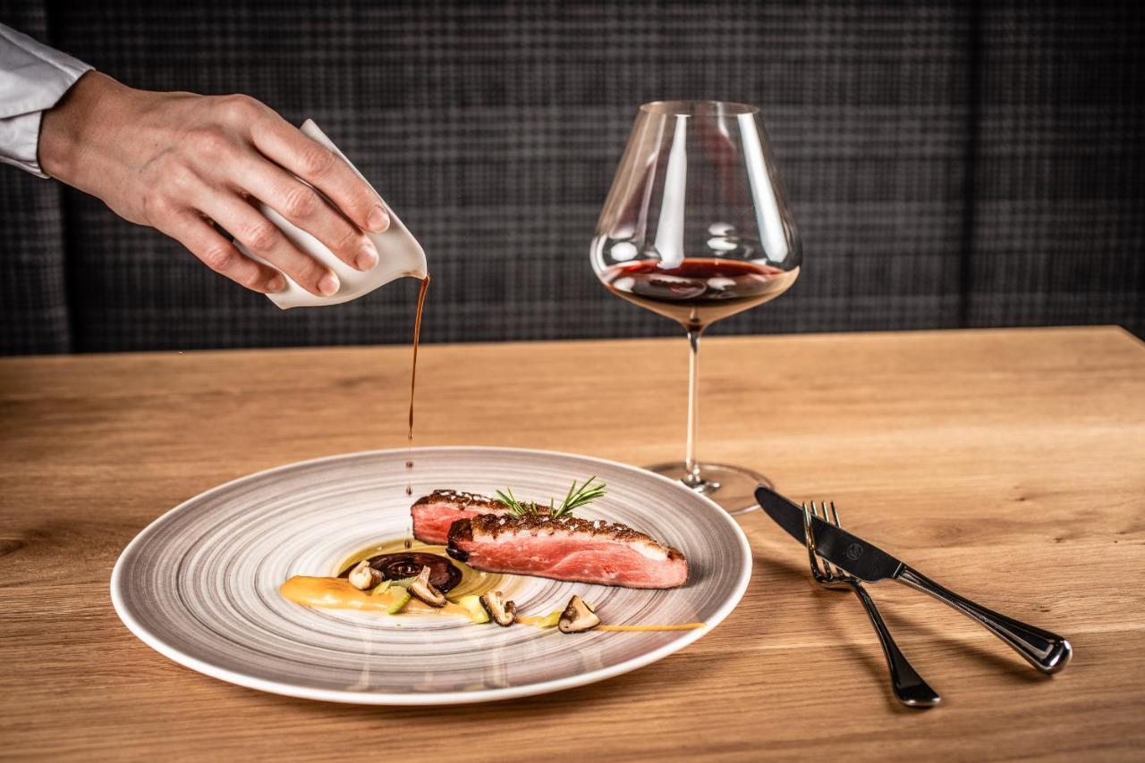 My Arbor - Dolomites Hotel Bressanone Kültér fotó A server pouring sauce onto a prepared dish